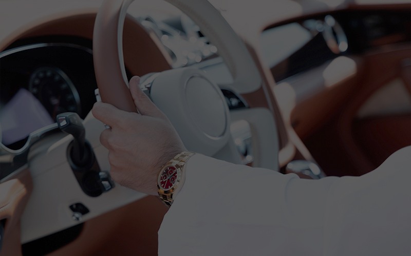 Wealthy man with gold watch driving car