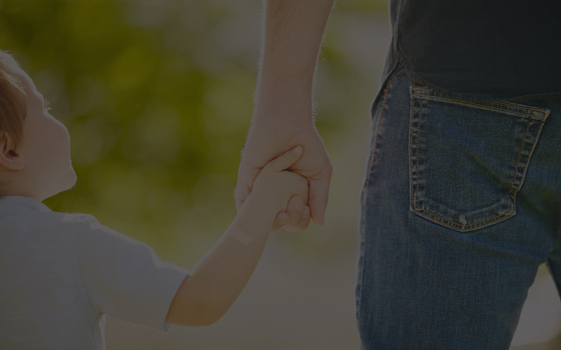 Father holding child's hand